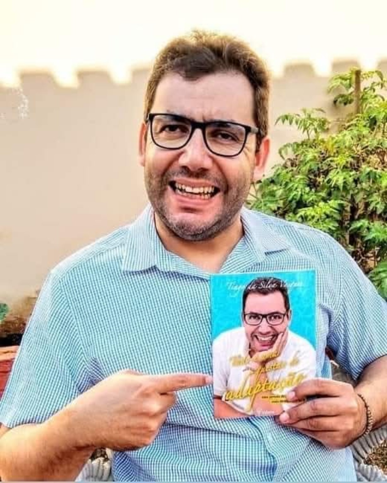 Tiago da Silva Vasques segurando a primeira edição do livro Tudo é uma Questão de Adaptação